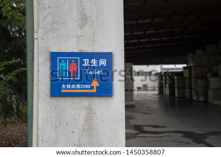 Factory Guidepost Blue Background. Translation: Toilet, Turn Left to West