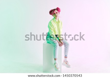 woman sitting on a neon style cube