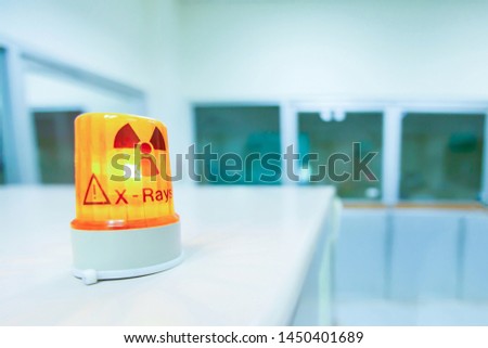 Ionizing radiation hazard symbol in x-ray laboratory, blurred laboratory interior for background. Royalty-Free Stock Photo #1450401689