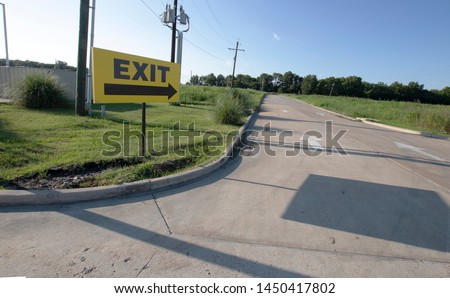  Exit sign outdoors pointing down a long road