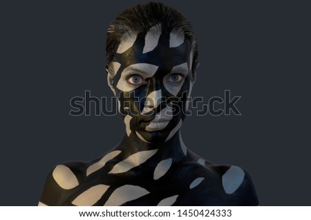 Creative makeup with black and gray stains on womens skin. Conceptual idea of bold body art painting.