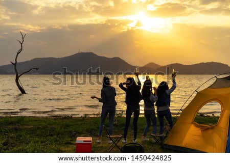 Silhouette.Group women party with drink alcohol enjoy at camping.Vacation time at sunset