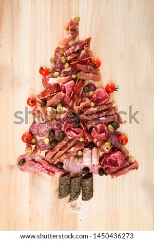 Christmas tree made of sausage on a background of wooden wall