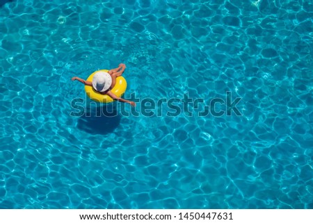 Woman swims on the inflatable circle in the pool. Up view. Summer and holiday concept