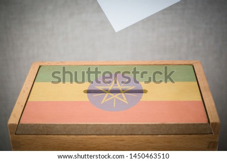 A wooden ballot box and voting paper carved with the flag of Ethiopia