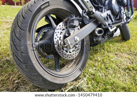 Sports motorcycle wheel close-up on grass background.
