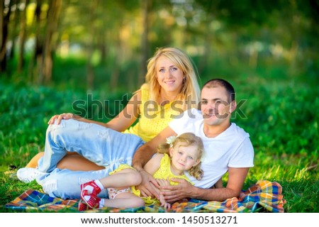 people concept. friendly family walks in a beautiful summer park. Lie on the blanket and have fun