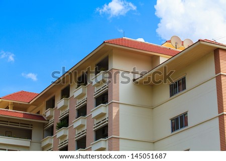 A view of hotel facade with modern style and blue sky.