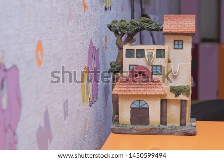 Small house model over wooden table outdoors  . Living room interior and holiday home decor concept. Toned picture . Miniature houses