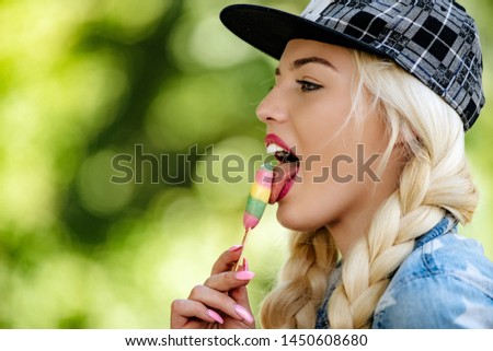 A girl in modern clothes with a skateboard lays ice cream