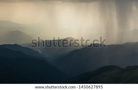 Rain and storm over the peak of the rodnei mountains in a cloudy summer day