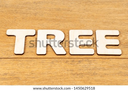 Word - tree, laid out in wooden letters on an old wooden table