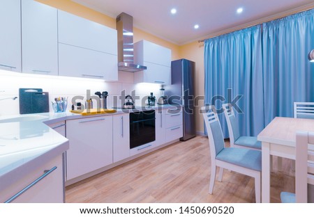 Beautiful interior apartment kitchen. Modern style. Design background. Home decoration. Llight yellow walls and blue curtains. Beige laminate floor. Fashion luxury room.