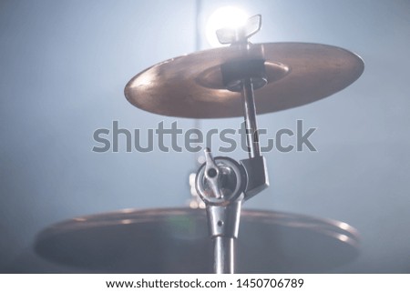 Close-up Drum set in a dark room against the backdrop of the spotlight. Atmospheric background symbol of playing rock or jazz drums. Copper plates on a cold background
