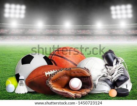 Sports equipment, rackets and balls for all seasons in stadium background with copy space.