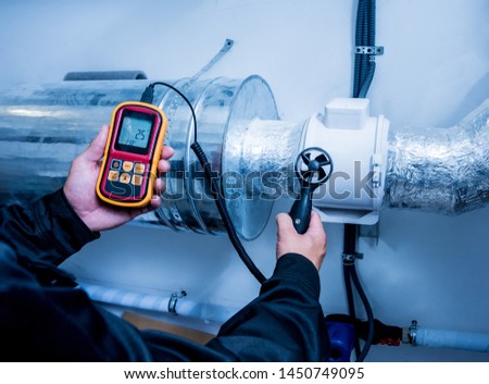 Technician use hand-held anemometer measuring air flowing measurement, wind speed and pressure. Modern equipment