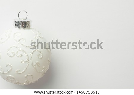 White ornament Christmas tree ball on same color monochrome background. New Year greeting card poster in Scandinavian minimalist style with copy space