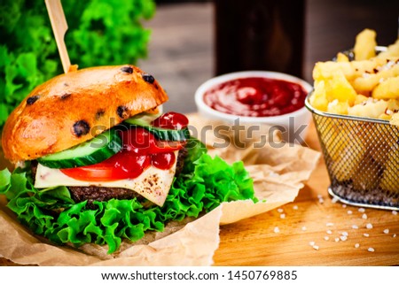 Tasty burgers with chips served on cutting board