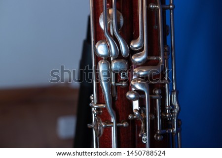 parts from a bassoon in front of a blue wall.