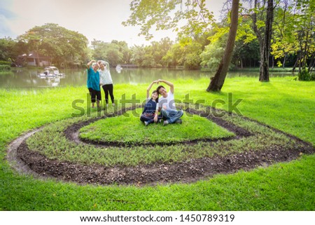 Happy asian family,daughter,father,mother,senior grandmother forming a heart with their hands,having fun,enjoy,laugh in outdoor park,cute child girl,elderly woman smile,love,generation,people concept