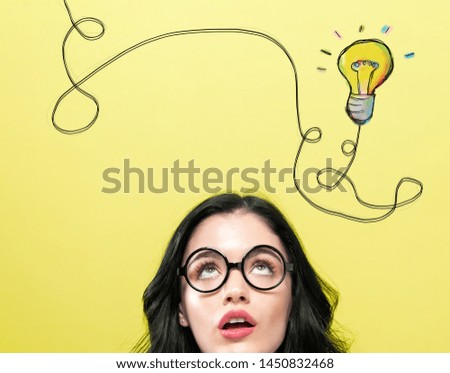 Light bulb with string with young woman wearing eye glasses