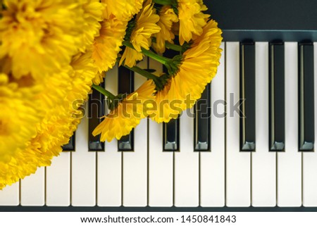 Flowers on a Piano. Bouquet of Yellow Chrysanthemum on a Piano Keyboard Close Up Top View