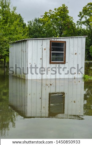 Old Acadian style structure, building with white metal walls, under flood waters due to hurricane Barry located in Delcambre, South Louisiana.