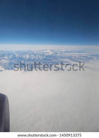 flying over Kabardino Balkaria, the view from the plane window - snow-capped mountains,in the distance mount Elbrus