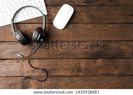 Customer support headset and computer on wooden desktop