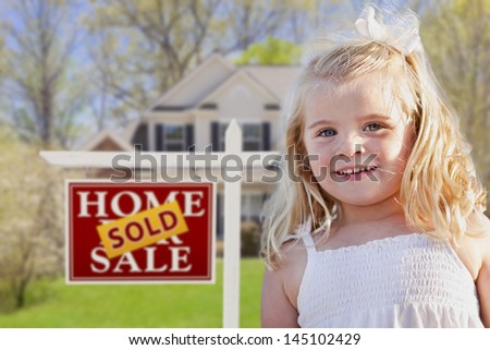 Cute Smiling Girl in Front Yard with Sold For Sale Real Estate Sign and House.