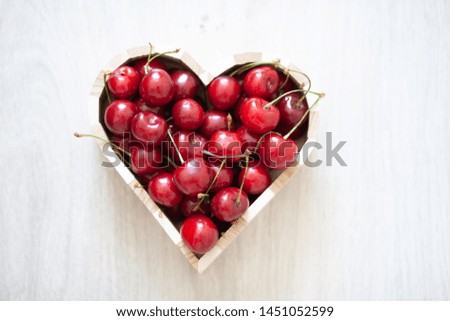Delicious sweet ripe and juicy berries. Sweet cherry lies in a box in the form of a heart.
