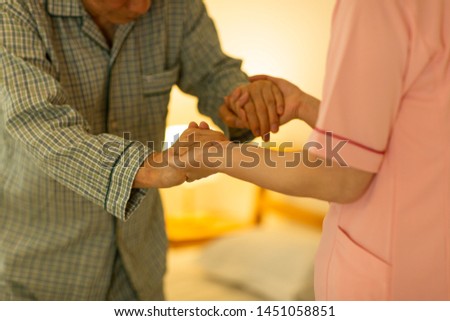 Senior man being cared by a female caregiver
