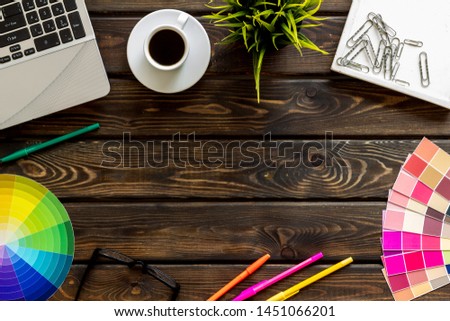 Designer office desk with tools, pallet, coffee, laptop and glasses on wooden background top view mock up