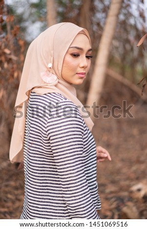 Beautiful young model in fashionable hijab style posing in burnt bush area. Stylish Muslim female hijab fashion lifestyle portraiture concept