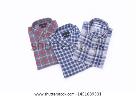three folded red, blue and white color long sleeve plaid shirts isolated on white background


