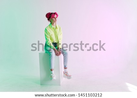 beautiful stylish clothes woman sitting on a cube on a white background