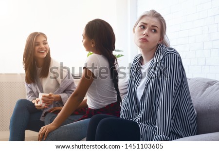 Lacking friends. Sad girl sitting alone, avoid talking to classmates, feeling lonely Royalty-Free Stock Photo #1451103605