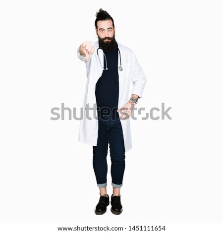 Doctor with long hair wearing medical coat and stethoscope looking unhappy and angry showing rejection and negative with thumbs down gesture. Bad expression.