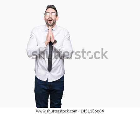 Young handsome business man wearing glasses over isolated background begging and praying with hands together with hope expression on face very emotional and worried. Asking for forgiveness. 