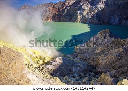 Smoke of sulfur toxic gas in the acidic crater lake of Kawah Ijen active volcano, Banyuwangi, East Java, Indonesia. Mount Ijen is the famous tourist attraction, where sulfur is mined.