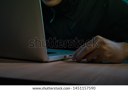 Man working on laptop in dark room
