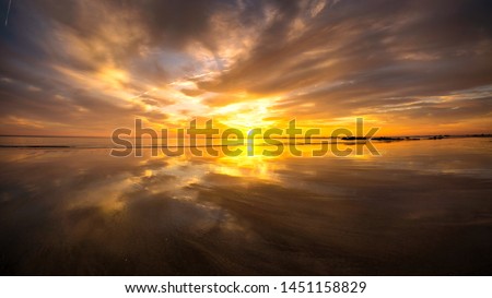 Dramatic sunset clouds over sea with reflection. Nature composition. Soft landscape theme.