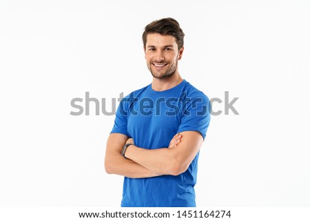 Attractive cheerful young fit sportsman wearing t-shirt standing isolated over white background, arms folded