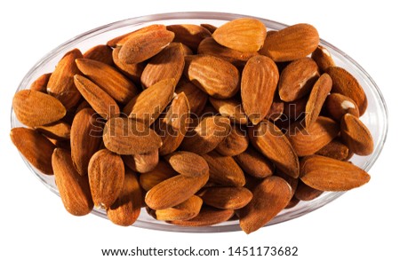 Close up of roasted salt almonds on glass bowl, nobody. Isolated over white background