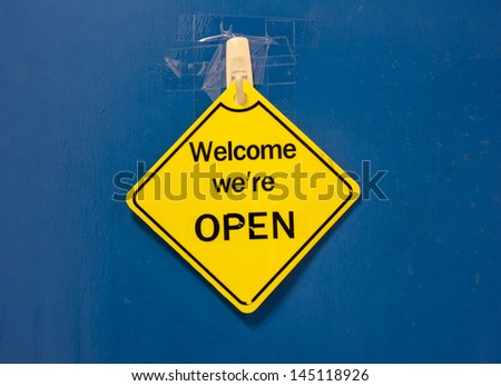 sign saying open against a blue door
