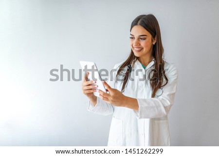 Woman doctor with stethoscope write on tablet at hospital ,isolated on grey. Doctor with tablet computer. Isolated over grey background. Portrait of a nurse using a digital tablet. Large copy-space