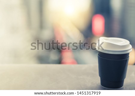 Blur background traffic city and cityscape panorama view from rooftop outdoor cafe with black coffee recycle paper cup help refresh break from urban morning lunch office worker life business meeting