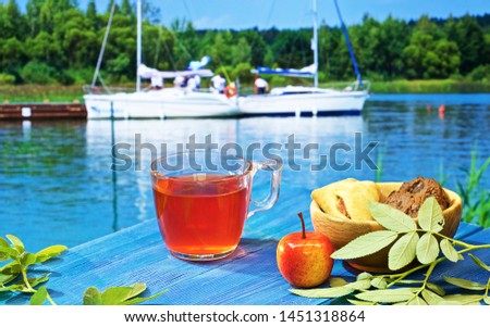 hot tea, teapot and sweets on a blue table on the background of a variety of beautiful landscapes