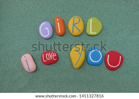 Girl, I love you, creative love message with colored stones over green sand