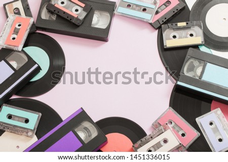 Collection of music tapes, records and video cassettes on paper background. Retro concept